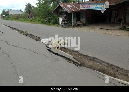 I residenti che passano il tratto di strada danneggiato con un veicolo dopo un forte terremoto il Mercoledì mattina qui a Pidie Jaya, provincia di Aceh, Indonesia, 10 dicembre 2016. Agenzia Dasril Roszandi/Anadolu (Foto di Dasril Roszandi/NurPhoto) *** si prega di utilizzare il credito dal campo di credito *** Foto Stock