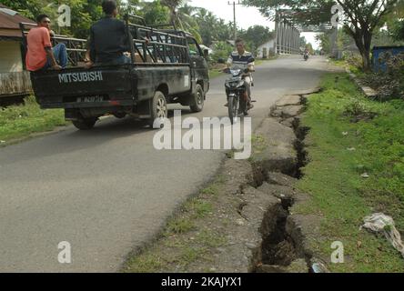 I residenti che passano il tratto di strada danneggiato con un veicolo dopo un forte terremoto il Mercoledì mattina qui a Pidie Jaya, provincia di Aceh, Indonesia, 10 dicembre 2016. Dasril Roszandi (Foto di Dasril Roszandi/NurPhoto) *** Please use Credit from Credit Field *** Foto Stock