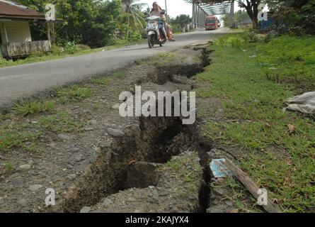 I residenti che passano il tratto di strada danneggiato con un veicolo dopo un forte terremoto il Mercoledì mattina qui a Pidie Jaya, provincia di Aceh, Indonesia, 10 dicembre 2016. Dasril Roszandi (Foto di Dasril Roszandi/NurPhoto) *** Please use Credit from Credit Field *** Foto Stock