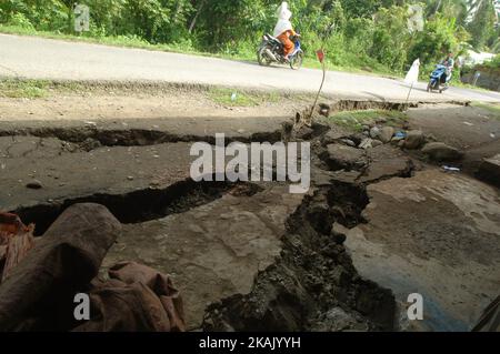 I residenti che passano il tratto di strada danneggiato con un veicolo dopo un forte terremoto il Mercoledì mattina qui a Pidie Jaya, provincia di Aceh, Indonesia, 10 dicembre 2016. Dasril Roszandi (Foto di Dasril Roszandi/NurPhoto) *** Please use Credit from Credit Field *** Foto Stock