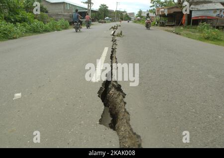 I residenti che passano il tratto di strada danneggiato con un veicolo dopo un forte terremoto il Mercoledì mattina qui a Pidie Jaya, provincia di Aceh, Indonesia, 10 dicembre 2016. (Foto di Dasril Roszandi/NurPhoto) *** Please use Credit from Credit Field *** Foto Stock