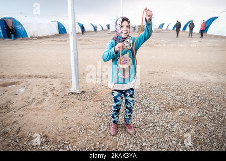 Foto scattata nel campo di Qayyarah Jadah vicino al campo di Qayyarah Jadah il 23 dicembre 2016. Ragazza con corda di salto fatta da sé. A due mesi dall'operazione militare per riconsiderare la città dallo Stato islamico dell'Iraq e dal Levante (ISIL), la crisi di Mosul continua ad avere un impatto umanitario significativo. I bisogni umanitari sono gravi tra le famiglie sfollate dentro e fuori dai campi, i vulnerabili residenti delle comunità appena ritirate e le persone che fuggono dai combattimenti nella città di Mosul. Lo sfollamento attuale è salito a 110.000 persone. Più di tre quarti delle famiglie sfollate si trovano nei campi e nei luoghi di emergenza, mentre l' Foto Stock