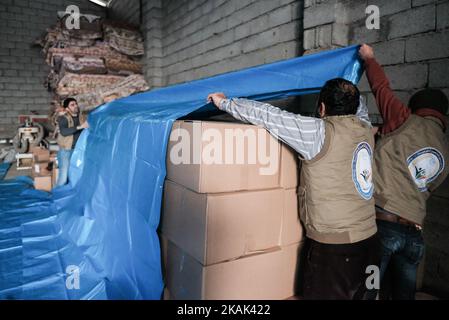 Volontari della ONG irachena RNVDO distribuzione di aiuti umanitari nel loro magazzino a Erbil, il 25 dicembre 2016. Le scatole contenenti i kit per l'igiene e il cibo saranno distribuite tra i civili che hanno dovuto fuggire dalle provincie tormentate dell'Iraq ma anche tornare alle loro case. Con decine di migliaia di persone provenienti da Mosul che ora si aggiungono ai quattro milioni di sfollati interni già presenti nel paese, la crisi dello sfollamento di IraqÂ è insostenibile, ha dichiarato Mark Lattimer, direttore esecutivo di Â MRGÂ. Â poiché le temperature scendono e si impedisce a un gran numero di sfollati interni di registrarsi per ricevere aiuti di Stato, l’Iraq si trova di fronte a una tragedia umanitaria Th Foto Stock