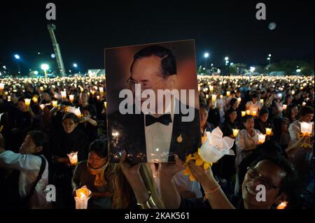 I thailandesi tengono in mano un'immagine del tardo re Bhumibol Adulyadej candele leggere mentre pregano durante il conto alla rovescia di Capodanno 2016 a Sanam Luang di fronte al Grand PalaceBangkok, Thailandia il 1 gennaio 2017. (Foto di Anusak Laowilas/NurPhoto) *** Please use Credit from Credit Field *** Foto Stock