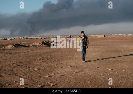 Crisi umanitaria vicino a Mosul in Iraq. Foto scattata nel campo di Qayyarah Jadah vicino al campo di Qayyarah Jadah il 03 gennaio 2017. Il campo di Jadah è influenzato da nube di fumo scuro e fuliggine da campi di petrolio che bruciano dove ISIL ha regolato Fire.The preoccupazione principale, secondo Oxfam, È che il fumo dai pozzi di petrolio causerà bronchite tra una popolazione che ha accesso a scarsa medicina.due mesi nell'operazione militare per ricontrarsi la città dallo Stato islamico dell'Iraq e del Levante (ISIL), la crisi di Mosul continua ad avere un impatto umanitario significativo. I bisogni umanitari sono gravi tra le famiglie sfollate Foto Stock