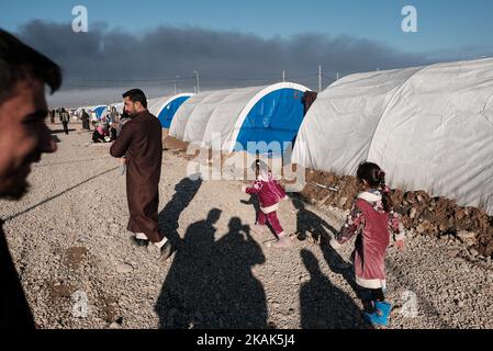 Crisi umanitaria vicino a Mosul in Iraq. Foto scattata nel campo di Qayyarah Jadah vicino al campo di Qayyarah Jadah il 03 gennaio 2017. Il campo di Jadah è influenzato da nube di fumo scuro e fuliggine da campi di petrolio che bruciano dove ISIL ha regolato Fire.The preoccupazione principale, secondo Oxfam, È che il fumo dai pozzi di petrolio causerà bronchite tra una popolazione che ha accesso a scarsa medicina.due mesi nell'operazione militare per ricontrarsi la città dallo Stato islamico dell'Iraq e del Levante (ISIL), la crisi di Mosul continua ad avere un impatto umanitario significativo. I bisogni umanitari sono gravi tra le famiglie sfollate Foto Stock