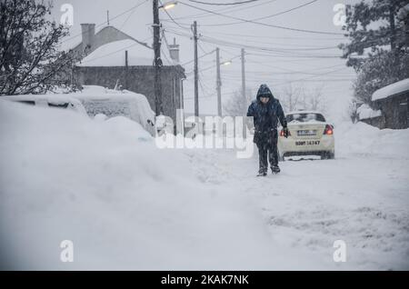 Un giovane cammina mentre la neve cade per le strade di Svilengrad, Bulgaria, il 11 gennaio 2017. Paralizza la neve in Bulgaria. La neve ha raggiunto 40 - 70 mq in luoghi diversi, il movimento è limitato e in alcune regioni sono bloccati. Ci sono molti villaggi senza acqua, elettricità con un po' di cibo. Le temperature dell'aria hanno raggiunto i -10 gradi celsius e in questo fatto alcuni dei grandi fiumi lungo il paese sono congelati. La popolazione della città di confine bulgara di Svilengrad, a circa 260 km a est dalla capitale di Sofia, non ha mai visto un inverno come questo il 11 gennaio 2017 (Foto di Hristo Rusev/NurPh Foto Stock