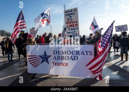 Un dimostratore porta segni e bandiere americane durante un raduno in solidarietà con i sostenitori della marcia femminile a Washington e in molte altre città il 21 gennaio 2017 di fronte alla Torre Eiffel a Parigi, un giorno dopo l'inaugurazione del presidente degli Stati Uniti Donald Trump. Manifestazioni di protesta si sono svolte in oltre 30 paesi in tutto il mondo in solidarietà con la marcia delle donne di Washington in difesa della libertà di stampa, dei diritti delle donne e dei diritti umani in seguito all'inaugurazione ufficiale di Donald J Trump come 45th presidente degli Stati Uniti d'America. (Foto di Julien Mattia/NurPhoto) *** Please use Cr Foto Stock