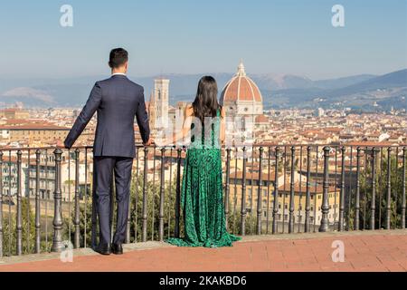 Una giovane coppia che gode di una vista sul Duomo di Firenze da un balcone Foto Stock