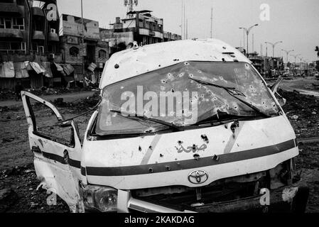 01/22/2017 Mosul, Iraq. Quartiere chiamato al Sukar. Come zucchero. Dovrebbe essere chiamata l'amarezza, almeno dopo che gente di questa città ha sperimentato. Le strade sono segnate da conchiglie, si possono trovare auto relitti sparsi in tutto il mondo. È difficile distinguere quale di essi dovrebbe essere usato in un attacco suicida. Alcuni viali si tormentano con vuoto, mentre gli altri migrano costantemente da un luogo all'altro. La gente vuole condividere le loro storie - 'là, accanto al negozio di pittura terrorista si è esploso'. I suoi resti giacciono sparsi in un mucchio di spazzatura. In realtà, CE ne erano due Foto Stock