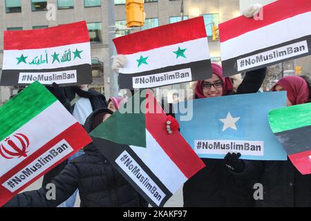 Le donne musulmane hanno dei segnali con le bandiere dei paesi vietati durante una massiccia protesta contro il divieto di viaggio del presidente Trump al di fuori del Consolato degli Stati Uniti nel centro di Toronto, Ontario, Canada, il 30 gennaio 2017. I canadesi si sono Uniti a paesi di tutto il mondo nel protestare contro l'ordine esecutivo del presidente americano Donald Trump, vietando i cittadini di sette paesi musulmani a maggioranza (Iran, Iraq, Sudan, Somalia, Siria, Yemen e Libia) di entrare negli Stati Uniti per i prossimi tre mesi e di vietare ai rifugiati siriani di entrare indefinitamente in America. (Foto di Creative Touch Imaging Ltd./NurP Foto Stock