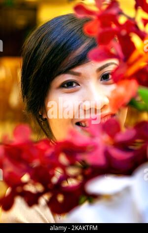 Attraente, vietnamita, ragazza, in posa, con, Flowerss, ho Chi Minh City, Vietnam, bello, giovane, giovane, donna, signora, volto, espressione, sorriso, felice Foto Stock