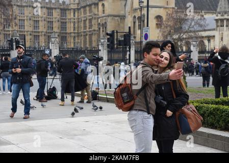 Una coppia prende un selfie di fronte al Parlamento dal lato sud del Tamigi il 24 marzo 2017 a Londra, Inghilterra. Una quarta persona è morta dopo che Khalid Masood ha guidato un'auto nei pedoni sul ponte di Westminster prima di andare a PC Keith Palmer fatalmente pugnalato il 22 marzo. (Foto di Alberto Pezzali/NurPhoto) *** Please use Credit from Credit Field *** Foto Stock