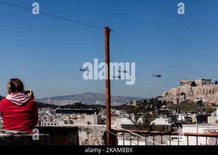 Una donna guarda elicotteri militari che volano sull'Acropoli durante la parata militare per commemorare l'inizio della guerra di indipendenza greca nel 1821. Atene, 25 marzo 2017. (Foto di Kostis Ntantamis/NurPhoto) *** Please use Credit from Credit Field *** Foto Stock