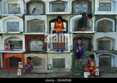 I bambini mangiano il loro Tawit nel cimitero di Carreta il 27 marzo 2017. Il cimitero di Carreta, di proprietà della Chiesa, costruito nel 1906 è uno dei più antichi e più grandi cantieri di Cebu City Filippine. Ospita non solo i morti, ma anche i vivi. Si stima che qui siano sepolti oltre 15.000 cadaveri e quasi 100 famiglie consideravano questo luogo come casa, con entrambi i numeri in aumento. (Foto di Ralph Piezas/NurPhoto) *** Please use Credit from Credit Field *** Foto Stock