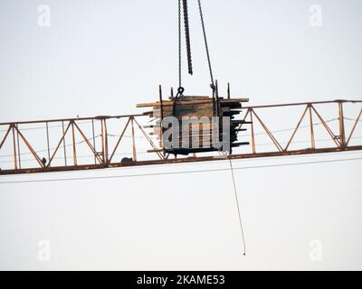 Un cantiere di nuovi edifici residenziali e di alto livello con gru per il trasporto di oggetti pesanti, focalizzazione selettiva delle torri di gru a livello inferiore Foto Stock