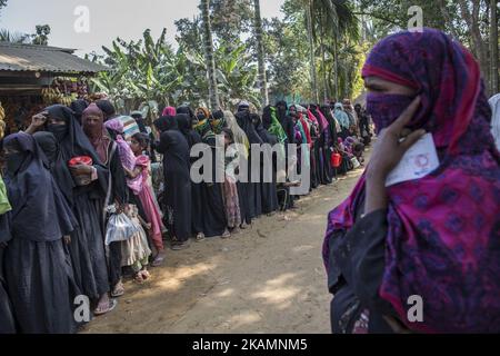 I rifugiati di Rohingya che sono fuggiti di recente dalla violenza in Myanmar aspettano in una lunga coda di cibo a Ukhia il 5 marzo 2017, il Bazar di Cox. Circa 70.000 musulmani Rohingya sono fuggiti dal Myanmar al Bangladesh dal 9 ottobre 2016 dopo che i militari birmani hanno lanciato operazioni di sdoganamento. L'ufficio per i diritti umani delle Nazioni Unite ha dichiarato nel loro rapporto che le forze di sicurezza del Myanmar hanno commesso uccisioni di massa, torture e stupri di bande di Rohingyas, così come hanno bruciato i loro villaggi. Rohingyas cominciò a fuggire dall'oppressione militare, prima nel 1978 e poi di nuovo nel 1991-92, in un afflusso maggiore di circa 500.000 persone. Pressione Foto Stock