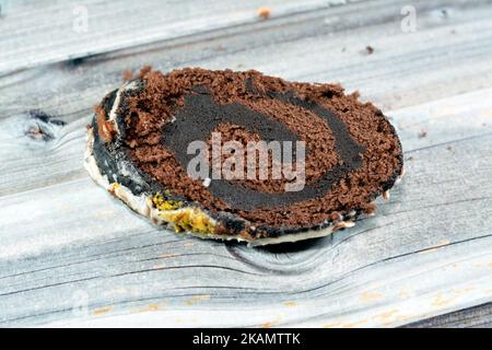 Un rotolo svizzero di torta al cioccolato, combinazione di una leggera torta di Spagna al cioccolato con panna montata alla vaniglia dolce e un dessert di ganache al cioccolato, coperto w Foto Stock