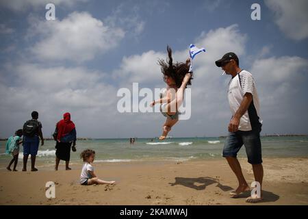 Una ragazza salta in aria mentre si posa per una foto dopo uno spettacolo aereo della squadra aeronautica israeliana come parte delle celebrazioni per il 69th° giorno dell'Indipendenza di Israele, a Tel Aviv, Israele, 2 maggio 2017. (Foto di Corinna Kern/NurPhoto) *** Please use Credit from Credit Field *** Foto Stock