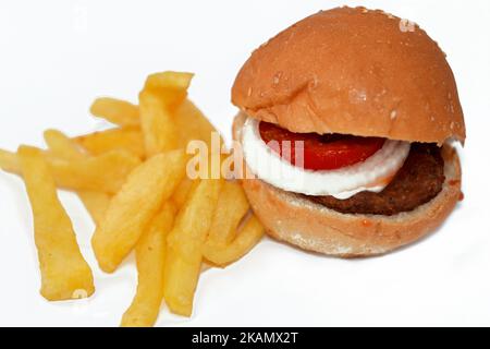 focus selettivo del panino hamburger di manzo con fette di anelli di cipolla e pomodori, con patatine fritte dita di patate isolate sul dorso bianco Foto Stock