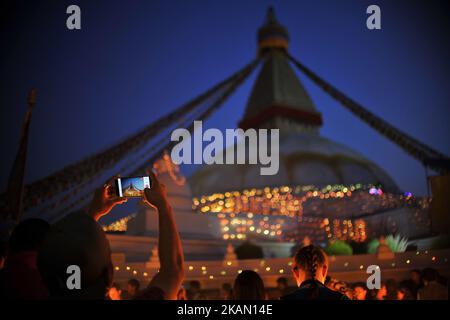 Un giovane nepalese che fotografa lo Stupa Boudhnath illuminato durante la celebrazione del 2.561° festival Buddha Purnima, anniversario della nascita del Buddha Lord Gautam a Kathmandu mercoledì 10 maggio 2017. Buddisti in tutto il mondo, Cambogia; Thailandia; Myanmar; Bhutan; Sri Lanka; Laos; Mongolia; Giappone; Singapore; Taiwan compreso il Nepal, osservare il Buddha Purnima festival che cade lo stesso giorno della luna piena del calendario del mese. L'occasione offre fiori, incenso e candele, uno scambio di doni come benedizioni, preghiere, sermoni e meditazioni di gruppo. (Foto di Narayan Maharjan/NurPhoto) *** P Foto Stock