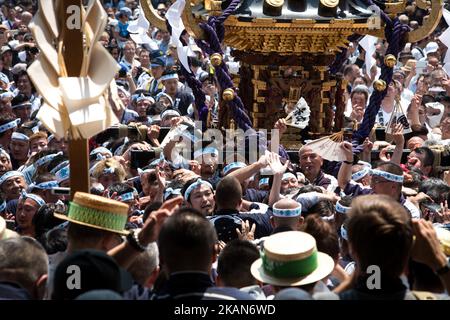 I residenti di Asakusa si riuniscono per portare un 'mikoshi' (santuari portatili) mentre cantano insieme durante il Festival di Sanja di fronte al Tempio senso-ji ad Asakusa, Tokyo, il 20 maggio 2017. Questi mikoshi sono trasportati nelle strade di Asakusa per portare fortuna, benedizioni e prosperità alla zona e ai suoi abitanti. (Foto di Richard Atrero de Guzman/NurPhoto) *** Please use Credit from Credit Field *** Foto Stock