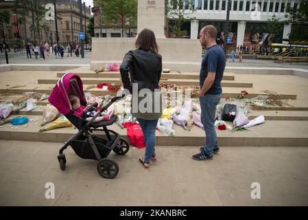 La gente guarda tributi floreali, per le vittime del bombardamento della Manchester Arena, in Piazza San Pietro a Manchester, Regno Unito Sabato, 27th maggio 2017. La polizia della Greater Manchester sta trattando l'esplosione dopo il concerto di Ariana Grande, che si è svolto il 05/22/2017 alla Manchester Arena, come un incidente terroristico. (Foto di Jonathan Nicholson/NurPhoto) *** Please use Credit from Credit Field *** Foto Stock