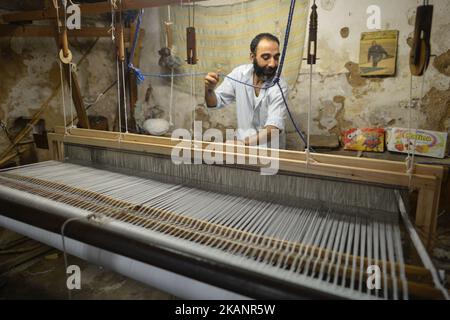 Un uomo locale utilizza una tradizionale macchina di tessitura a mano in una piccola fabbrica di famiglia all'interno di Fes Medina. Una scena da una vita quotidiana a Fes durante il Ramadan 2017. Sabato 17 giugno 2017, a Fes, Marocco. (Foto di Artur Widak/NurPhoto) *** Please use Credit from Credit Field *** Foto Stock