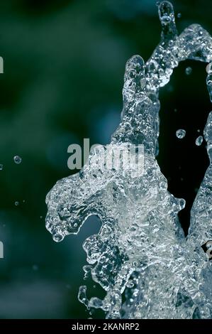 Un primo piano di spruzzi d'acqua nell'aria su sfondo sfocato Foto Stock