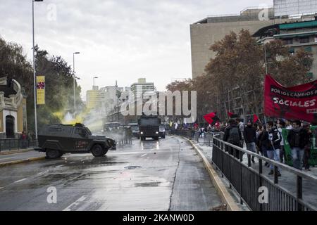 Un cannone ad acqua della polizia rilascia un getto d'acqua su un veicolo della polizia su cui i manifestanti gettavano la vernice. Guidata dalla Confederazione degli studenti cileni (CONFECH), la marcia per l'educazione universale si conclude in uno scontro con la polizia a Santiago il 21 giugno 2017. I partecipanti alla marcia si oppongono e respingono le riforme educative proposte dal governo della Presidente Michelle Bachelet. (Foto di Mauricio Gomez/NurPhoto) *** Please use Credit from Credit Field *** Foto Stock