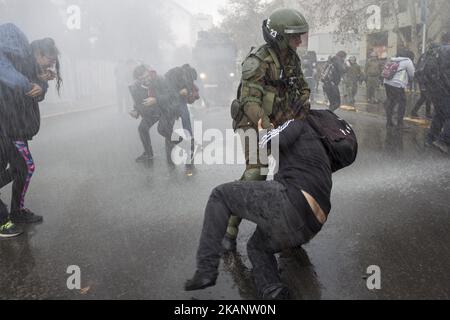 Un protester è arrestato sotto l'acqua gettato da automobili del cannone dell'acqua. Guidata dalla Confederazione degli studenti cileni (CONFECH), la marcia per l'educazione universale si conclude in uno scontro con la polizia a Santiago il 21 giugno 2017. I partecipanti alla marcia si oppongono e respingono le riforme educative proposte dal governo della Presidente Michelle Bachelet. (Foto di Mauricio Gomez/NurPhoto) *** Please use Credit from Credit Field *** Foto Stock