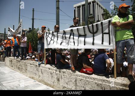 Manifestanti con bandiera che recita - occupazione - all'ingresso del Parlamento greco durante una marcia di protesta organizzata dalla Federazione dei lavoratori nei comuni di Atene il 22 giugno 2017. Il sindacato POE-OTA sta organizzando uno sciopero di 24 ore e ha organizzato la marcia per protestare contro le carenze di personale derivanti dalla scadenza di centinaia di contratti a breve termine. (Foto di Panayotis Tzamaros/NurPhoto) *** Please use Credit from Credit Field *** Foto Stock