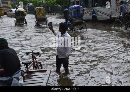 Cittadini, veicoli e risciò provano a guidare con i passeggeri attraverso le strade allagate della città di Dhaka dopo che il pesante deflusso ha causato quasi-arresto, il 05 luglio 2017. Dopo le forti piogge monsoniche provocarono l'allagamento della maggior parte della zona nella capitale di Dhaka, in Bangladesh. Le strade sono state parzialmente sommerse rendendo il viaggio pericoloso. Un certo numero di risciò di ciclo rovesciato nell'acqua. (Foto di Mamunur Rashid/NurPhoto) *** Please use Credit from Credit Field *** Foto Stock