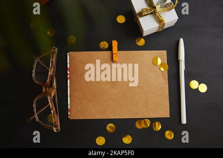 Estetica femminile mockup di cartellonistica artigianale, busta tra le vacanze scintillante. Natale augurando e presente. Foto Stock