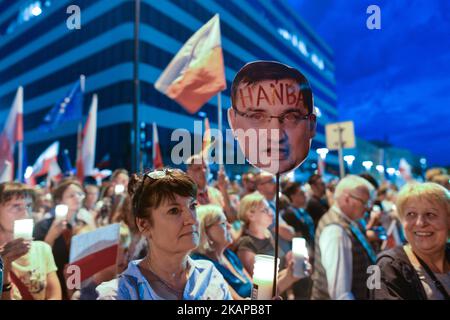 Una signora tiene un'immagine dell'attuale ministro della Giustizia Zbigniew Ziobro con la parola 'vergogna' scritta sulla fronte, Nel corso di una veglia anti-governativa a lume di candela di fronte alla corte distrettuale di Cracovia, lunedì sera, dove centinaia di persone si sono riunite per l'ottava notte consecutiva chiedendo al presidente polacco di porre il veto alla terza proposta in relazione alla riforma giudicale. Lunedì 24 luglio 2017 a Cracovia, Polonia. Foto di Artur Widak *** Please use Credit from Credit Field *** Foto Stock