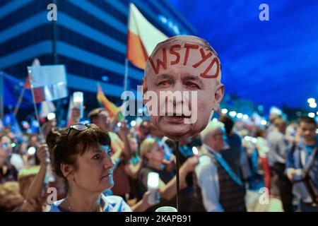 Una signora tiene un'immagine del volto del presidente del PIS Jaroslaw Kaczynski con la parola 'vergogna' scritta sulla fronte, Nel corso di una veglia anti-governativa a lume di candela di fronte alla corte distrettuale di Cracovia, lunedì sera, dove centinaia di persone si sono riunite per l'ottava notte consecutiva chiedendo al presidente polacco di porre il veto alla terza proposta in relazione alla riforma giudicale. Lunedì 24 luglio 2017 a Cracovia, Polonia. Foto di Artur Widak *** Please use Credit from Credit Field *** Foto Stock