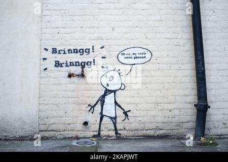Il telefono Tap di Banksy, noto come My Tap's è stato telefonato a East London, Regno Unito, il 13 agosto 2017. Banksy ha etichettato un muro con una giocosa e spensierata riprovazione contro lo scandalo di pirateria telefonica di Rupert Murdoch. Raffigura un rubinetto d'acqua (un vero rubinetto che si trova sulla parete e che è incorporato nell'opera d'arte) con un suono simulato del telefono e una persona confuso con una figura di bastone. (Foto di Alberto Pezzali/NurPhoto) *** Please use Credit from Credit Field *** Foto Stock