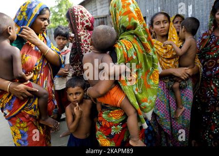 Le donne vengono a ricevere sollievo da un deputato locale del partito governante a Jammola, Sariakandi, Bogra, Bangladesh 17 agosto 2017. Secondo le autorità, le alluvioni causate da forti precipitazioni in Bangladesh durante la scorsa settimana hanno causato almeno 56 morti. Le persone colpite attendono di ricevere più sollievo perché nei centri di accoglienza mancano cibo e acqua potabile. (Foto di KM Asad/NurPhoto) Foto Stock