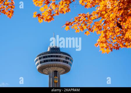 Cascate del Niagara, Ontario, Canada - Ottobre. Skylon Tower, autunno acero foglie sul cielo blu. Fogliame autunnale a Niagara Falls City. Foto Stock
