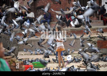 Una bambina che gioca con piccione a Basantapur Durbar Square, Kathmandu, Nepal Domenica 03 settembre 2017. (Foto di Narayan Maharjan/NurPhoto) Foto Stock