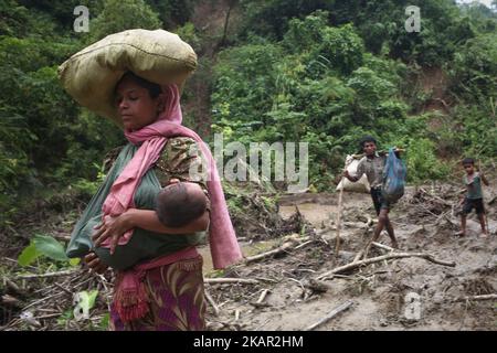 Una donna rohingya trasporta il suo bambino in una fionda mentre cammina attraverso la collina dopo aver attraversato il confine in Bangladesh vicino alla zona bazar di cox, teknaf. 5 settembre 2017 Un totale di 87.000 rifugiati Rohingya sono arrivati in Bangladesh da quando è scoppiata la violenza nella vicina Myanmar il 25 agosto, le Nazioni Unite hanno detto oggi, tra le crescenti critiche internazionali nei confronti di Aung San Suu Kyi. Circa 20.000 altri sono stati massacrati alla frontiera in attesa di entrare, ha affermato l'ONU in una relazione. (Foto di Mushfiqul Alam/NurPhoto) Foto Stock