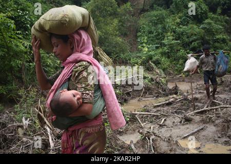 Una donna rohingya trasporta il suo bambino in una fionda mentre cammina attraverso la collina dopo aver attraversato il confine in Bangladesh vicino alla zona bazar di cox, teknaf. 5 settembre 2017 Un totale di 87.000 rifugiati Rohingya sono arrivati in Bangladesh da quando è scoppiata la violenza nella vicina Myanmar il 25 agosto, le Nazioni Unite hanno detto oggi, tra le crescenti critiche internazionali nei confronti di Aung San Suu Kyi. Circa 20.000 altri sono stati massacrati alla frontiera in attesa di entrare, ha affermato l'ONU in una relazione. (Foto di Mushfiqul Alam/NurPhoto) Foto Stock