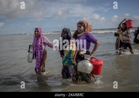 Le donne rifugiate Rohingya camminano verso la riva del Bangladesh dopo aver attraversato il fiume NaF in barca. Shahpirer DIP, Teknaf, Bangladesh; 14 settembre 2017. Il Bangladesh utilizzerà le truppe per fornire aiuti esteri alla città di confine che è stata sopraffatta dai rifugiati musulmani di Rohingya provenienti dal Myanmar, le autorità hanno annunciato la fine di settembre 14. La mossa fa seguito alle critiche sulle condizioni caotiche in cui le forniture di soccorso sono state distribuite negli enormi campi intorno al Bazar di Cox, dove circa 389.000 Rohingya dallo stato di Rakhine del Myanmar sono arrivati dall'agosto 25. (Foto di Turjoy Chowdhury/NurPhoto) Foto Stock