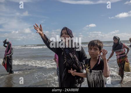 I rifugiati di Rohingya camminano verso la riva del Bangladesh dopo aver attraversato il fiume NaF in barca. Shahpirer DIP, Teknaf, Bangladesh; 14 settembre 2017. Il Bangladesh utilizzerà le truppe per fornire aiuti esteri alla città di confine che è stata sopraffatta dai rifugiati musulmani di Rohingya provenienti dal Myanmar, le autorità hanno annunciato la fine di settembre 14. La mossa fa seguito alle critiche sulle condizioni caotiche in cui le forniture di soccorso sono state distribuite negli enormi campi intorno al Bazar di Cox, dove circa 389.000 Rohingya dallo stato di Rakhine del Myanmar sono arrivati dall'agosto 25. (Foto di Turjoy Chowdhury/NurPhoto) Foto Stock