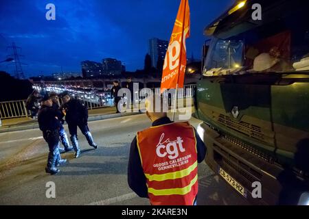 I camionisti del sindacato dei lavoratori francesi CGT bloccano le strade di accesso al porto di Gennevilliers, fuori Parigi, Francia il 25 settembre 2017, all'inizio di uno sciopero dei camionisti contro le riforme governative del lavoro del presidente Emmanuel Macron. I camionisti hanno iniziato uno sciopero rinnovabile la notte del 24 settembre, che dovrebbe essere seguito in diverse principali città francesi, rallentando il traffico e bloccando siti industriali e depositi petroliferi. La riforma del lavoro di punta arriva pochi giorni dopo che il presidente francese ha firmato le riforme attraverso una procedura accelerata che consente di rinunciare al parlamento Foto Stock