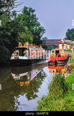 Canalboats sul canale di Worcester e Birmingham a Dunhampton, vicino a Droitwich, Worcestershire nel 1980. Barche colorate e abiti anni '80. Foto Stock