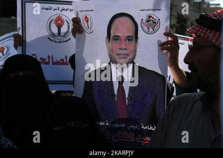 I residenti tengono foto del presidente egiziano Abdel-Fattah el-Sissi durante l'incontro del primo ministro palestinese Rami Hamdallah e del capo dell'intelligence generale egiziano Khaled Fawzy, presso l'ex funzionario del presidente palestinese Mahmoud Abbas residente a Gaza City, martedì 3 ottobre 2017. Hamdallah ha tenuto la prima riunione del governo a Gaza come parte di un grande sforzo di riconciliazione per porre fine alla frattura di 10 anni tra Fatah e il militante gruppo Hamas. (Foto di Majdi Fathi/NurPhoto) Foto Stock