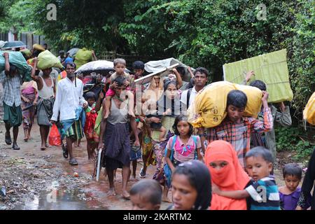 La gente di Rohingya, fuggita dall'operazione militare in corso nello stato di Myanmar Rakhain, cammina lungo la strada all'isola di Shah pori per andare al campo profughi nell'isola di Shah pori in Bangladesh il 07 ottobre 2017. Il popolo di Rohinngya è fuggito continuando in Bangladesh. Il Bangladesh ha affermato che sarebbe stata una delle più grandi camme di rifugiati del mondo ad ospitare tutti i 800.000 più musulmani Rohingya che hanno cercato asilo dalla violenza in Myanmar. (Foto di Zakir Hossain Chowdhury/NurPhoto) Foto Stock