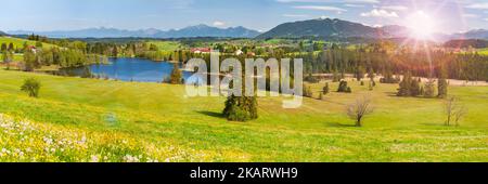 Landschaft im Allgäu mit See, Gebirge und Sonne Foto Stock