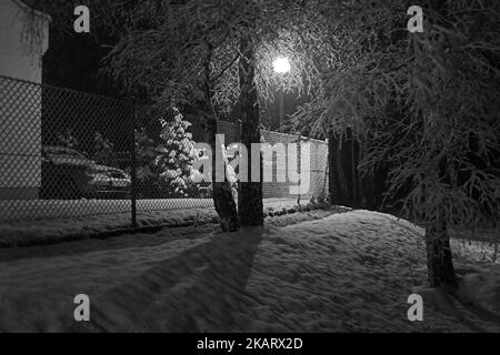 Ostrzeszów, Polska, Polonia, Polen; scenario invernale, Scenario innevato di notte illuminato da una lampada da strada; verschneite Winterlandschaft bei Nacht Foto Stock